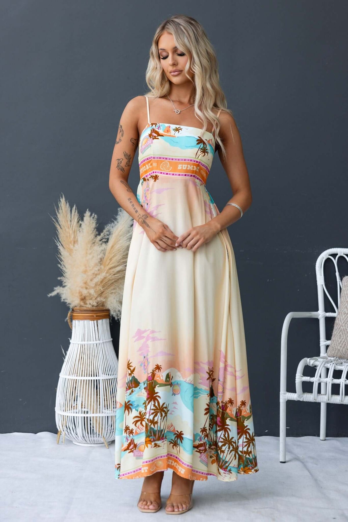 Salilah Maxi Dress featuring thin adjustable straps, shirred back panel, pockets, and vibrant tropical print.