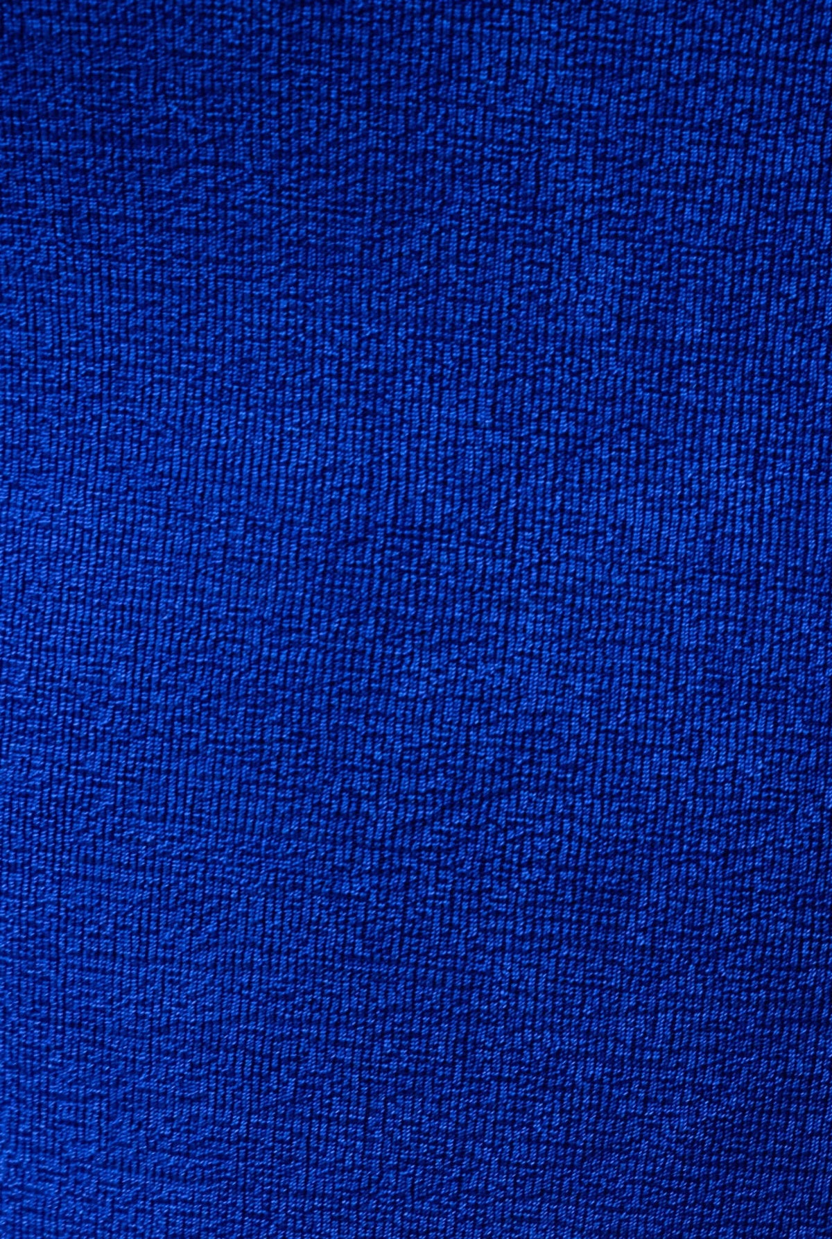Close-up of textured blue fabric, showcasing a rich, deep blue color with a subtle pattern.