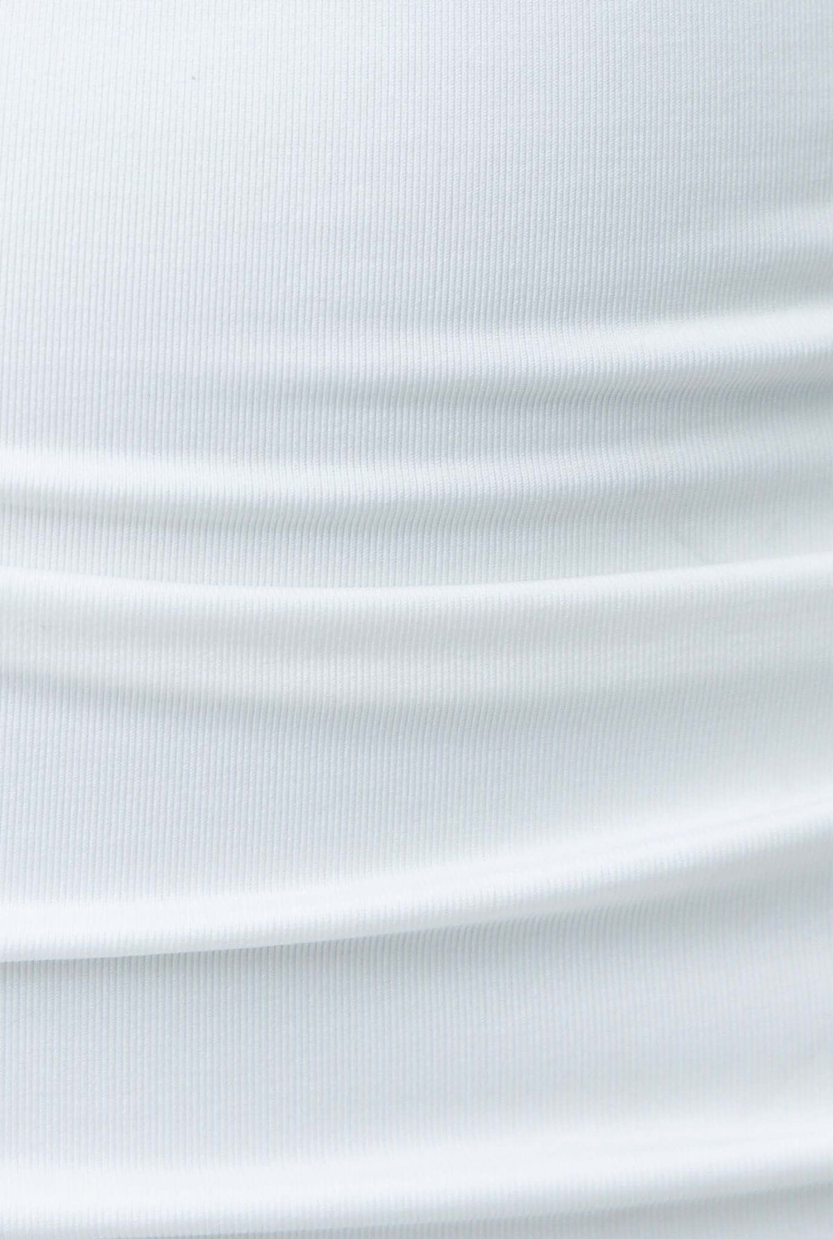 Close-up of white fabric with soft ribbed texture, showcasing lightweight and stretchable material.