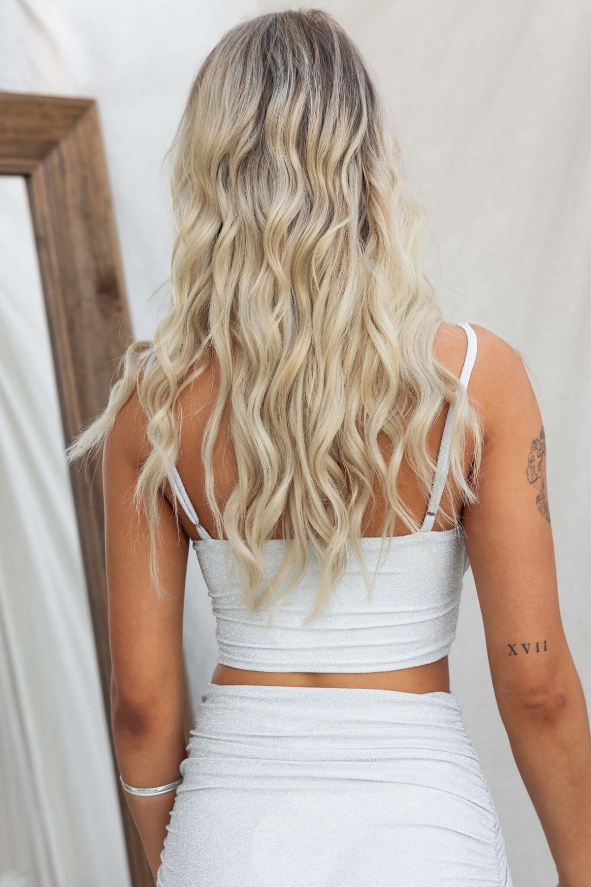 Back view of a woman wearing the Bemmie Top, featuring adjustable straps and a metallic fabric finish.