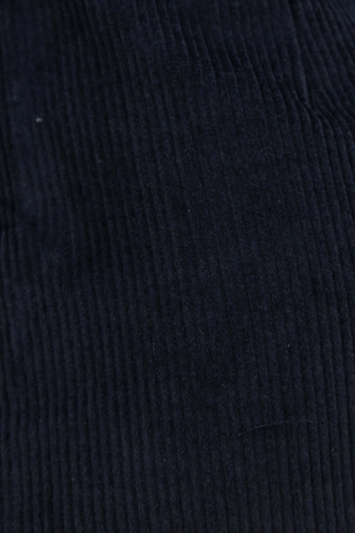 Close-up of black corduroy fabric texture from the Pierre skirt, showcasing its ribbed pattern.