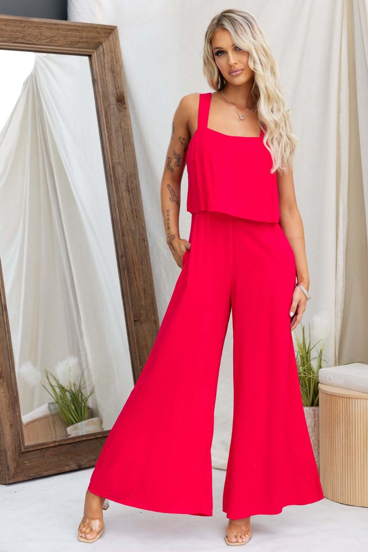 Model wearing a red Verko jumpsuit with a relaxed fit, featuring pockets and an invisible zip at the back.