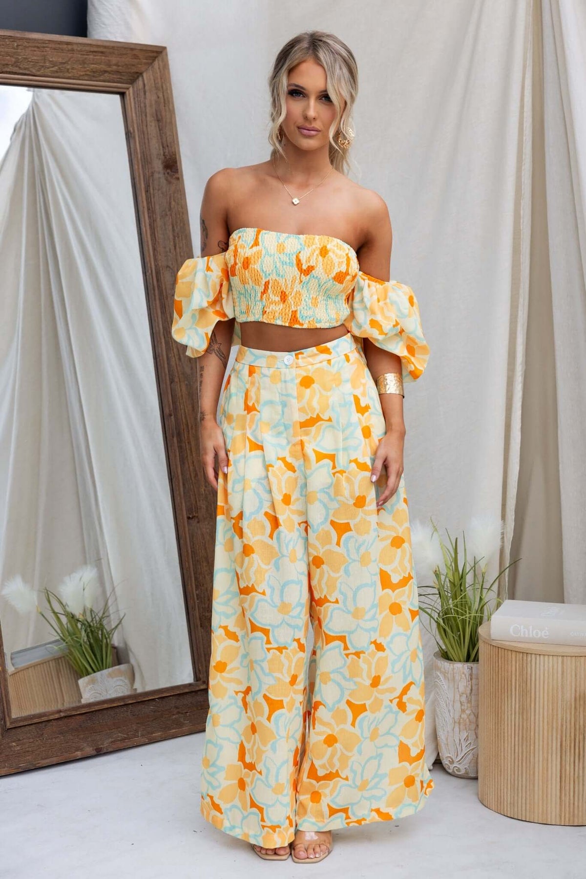 Olessia Set: Floral two-piece outfit featuring a cropped top and wide-leg pants in vibrant yellow and blue.
