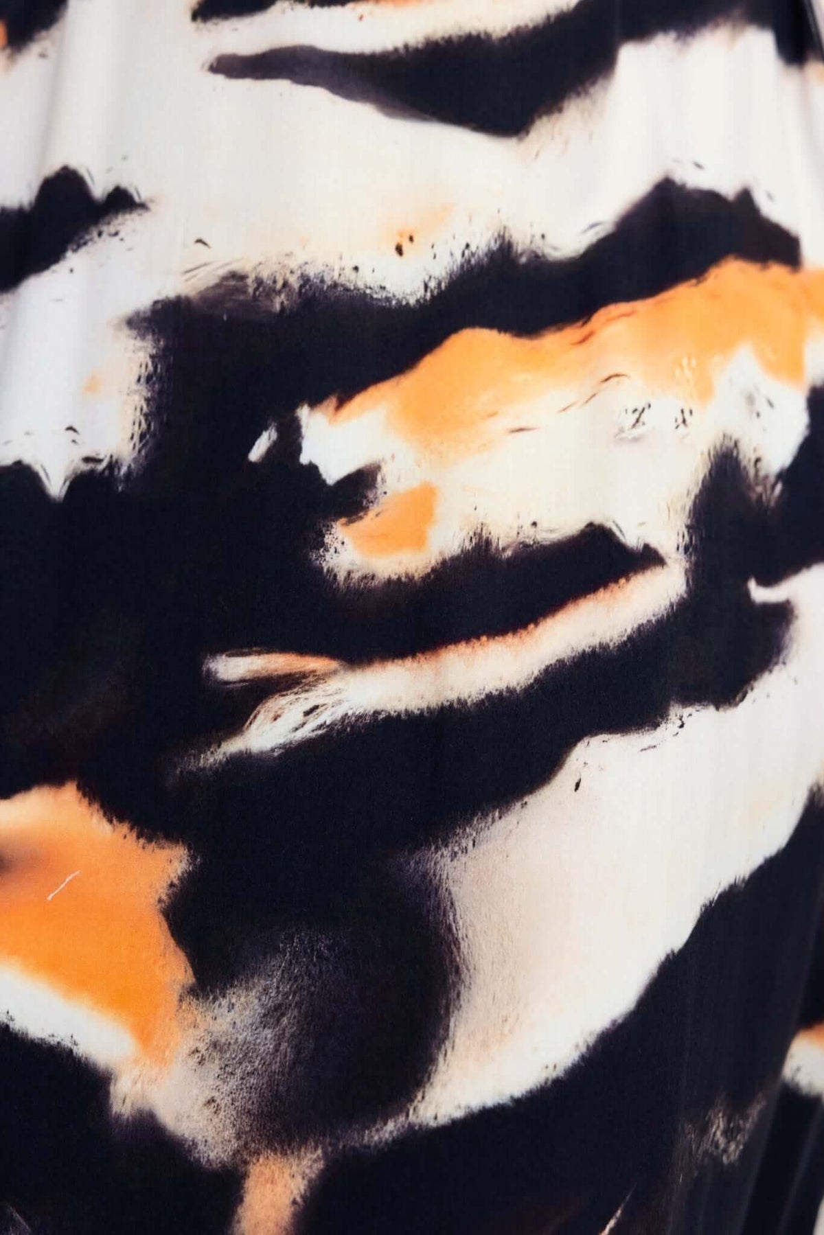 Cecilee Midi Dress close-up featuring abstract black and orange pattern on fabric for a stylish look.