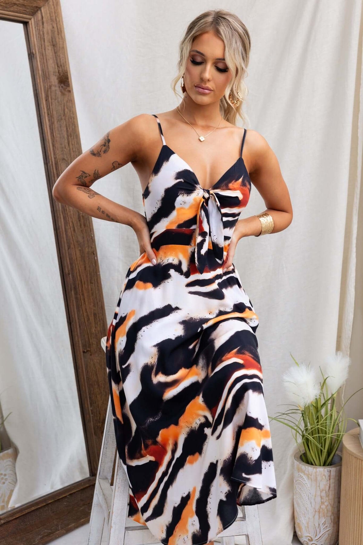 Cecilee Midi Dress featuring adjustable straps, tie at bust, and a striking multicolor pattern, displayed on a model.