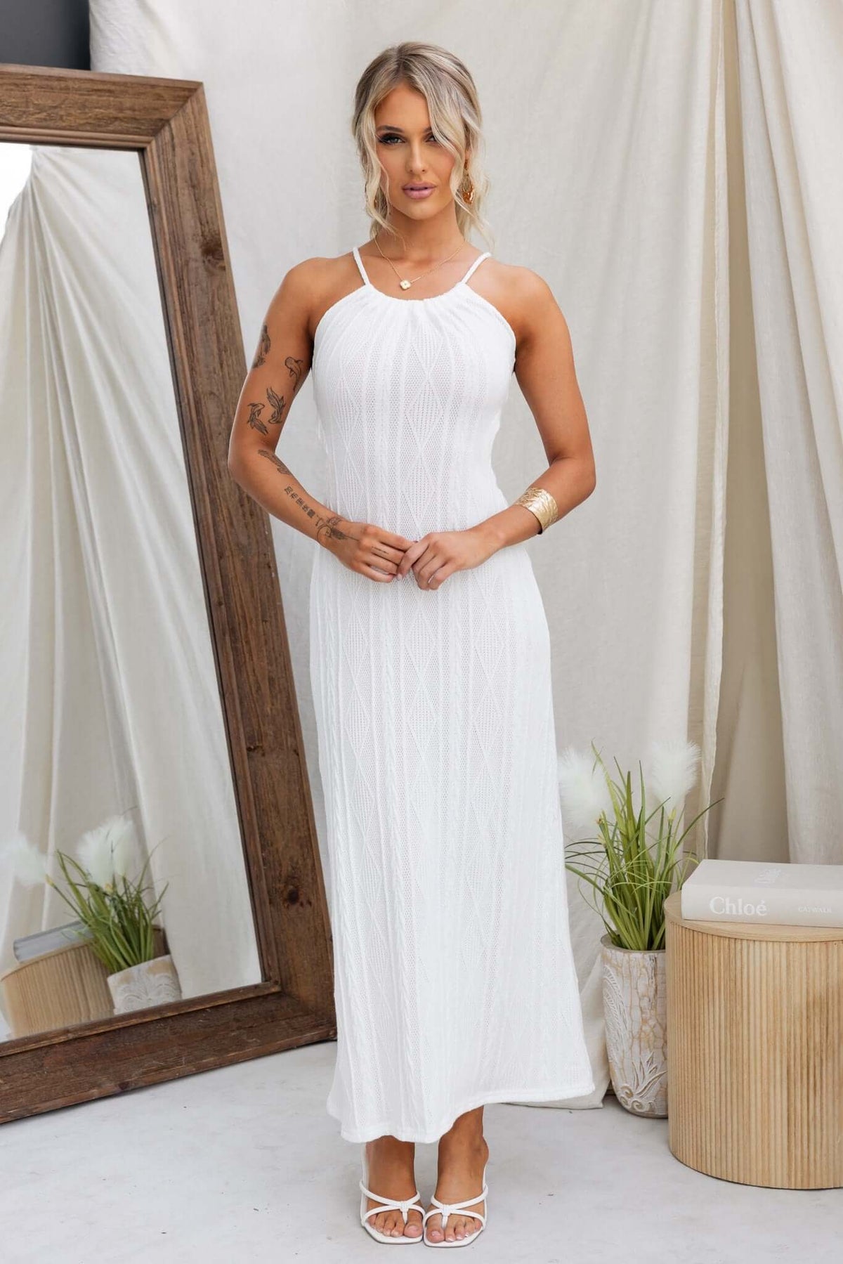 Model wearing the Dream Weaver Maxi Dress, a white tie neckline dress with cut-out back, featuring a flowing silhouette.