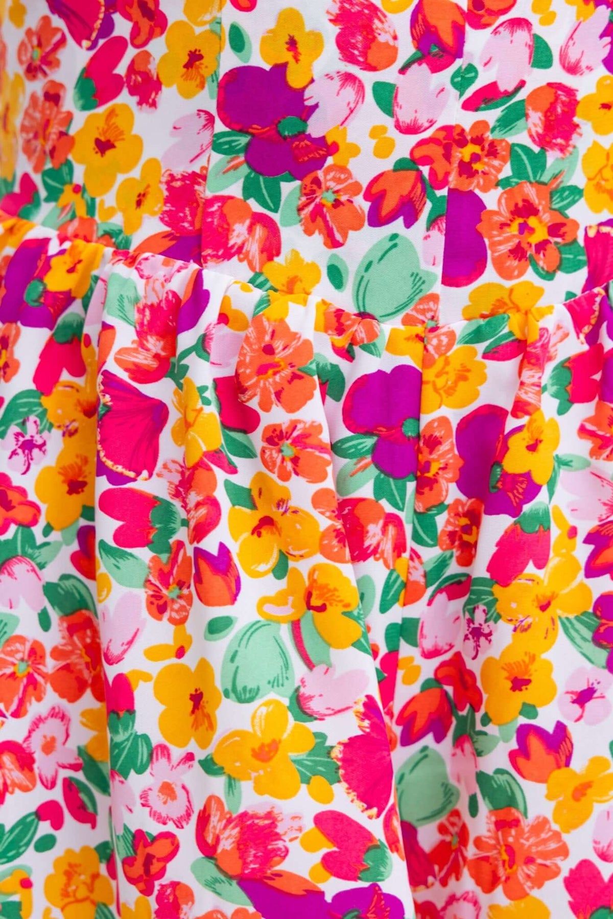 Close-up of colorful floral pattern on the Kaycee Playsuit, featuring vibrant pink, orange, and yellow flowers.