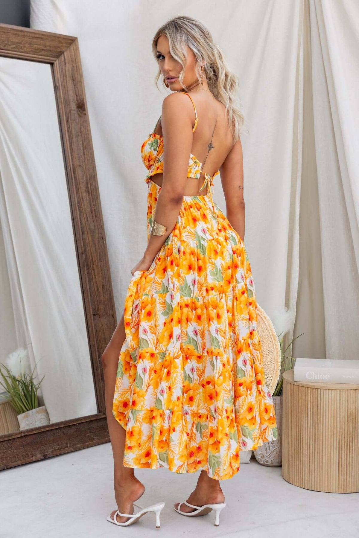 Kohana Maxi Dress featuring adjustable straps, tie back, and vibrant floral pattern, modeled from the back.