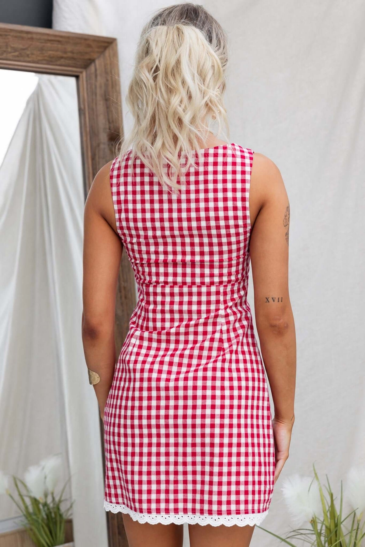 Back view of Kairyn Dress featuring a red and white gingham pattern with a high neckline and lace trim.