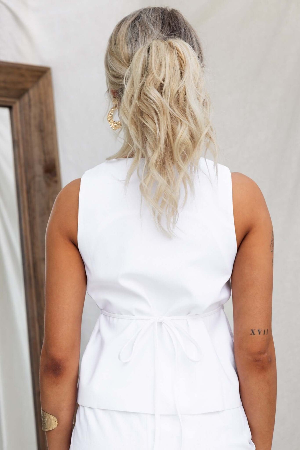 Back view of Vaylor Top featuring a tied waist, sleeveless design, and elegant white fabric.