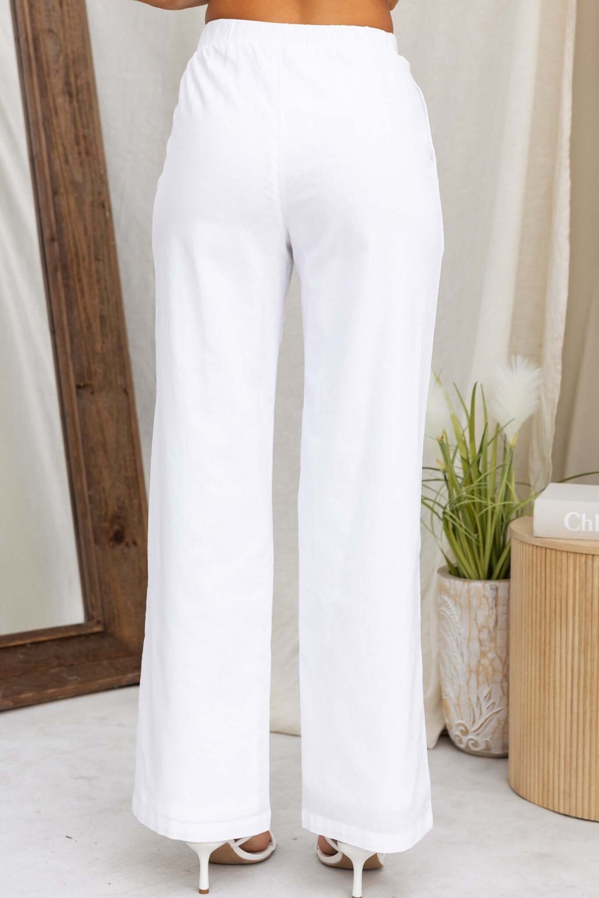 Back view of Vaylor Pants, featuring a mid-high waist, elastic waistband, and a tailored fit in white.