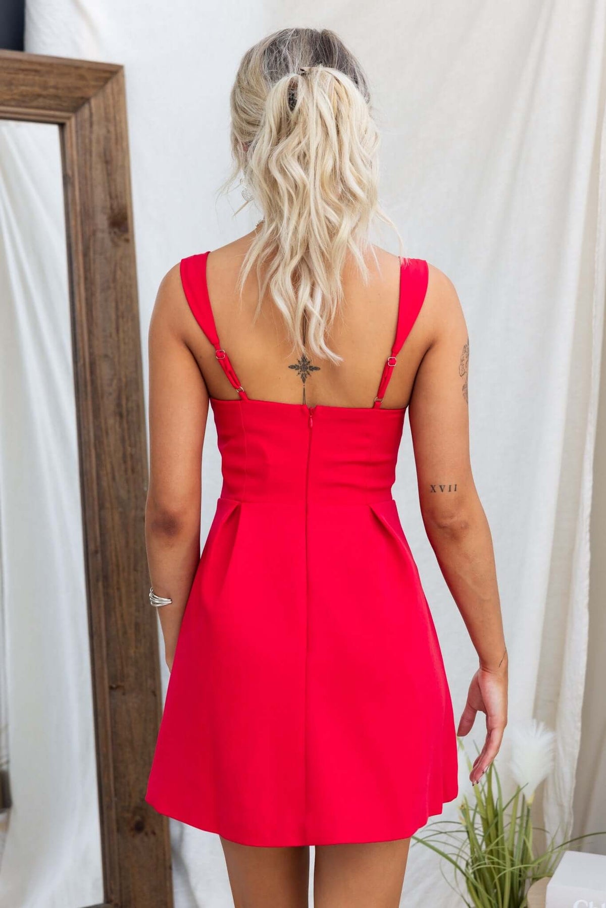 Back view of the Franklin Dress featuring adjustable straps and pleated design in vibrant red, perfect for casual or formal events.