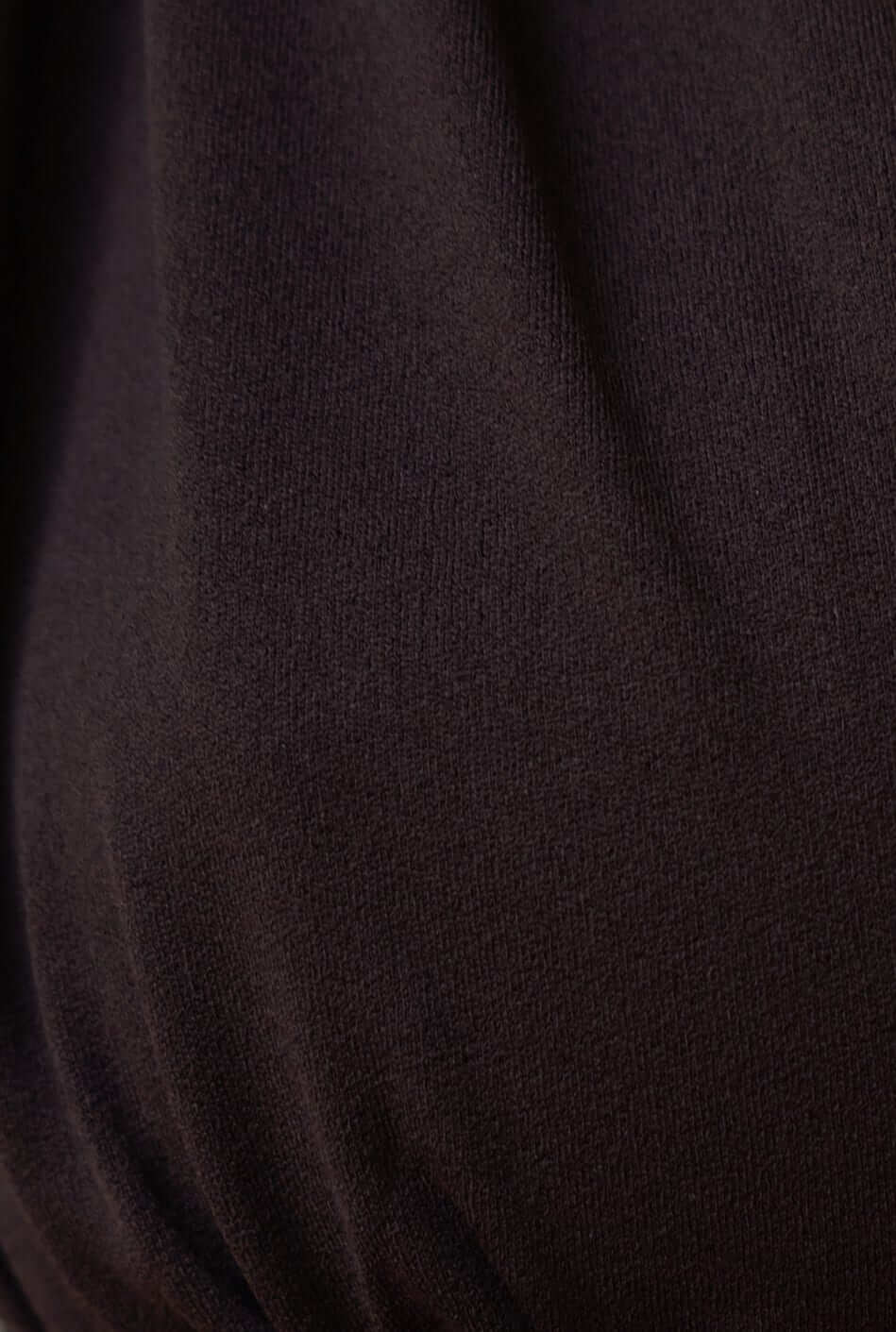 Close-up of soft black fabric showcasing stretch and texture of the Kattan Top.