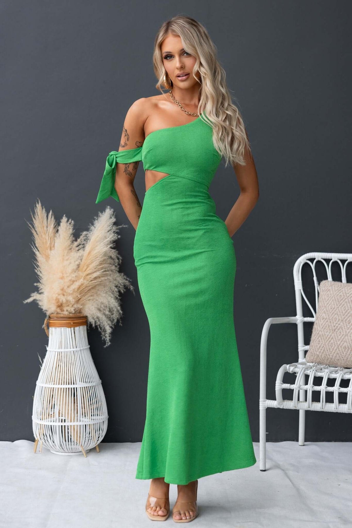 Malian maxi dress featuring a one-shoulder neckline, cut-out at waist, and attached tie, in vibrant green.
