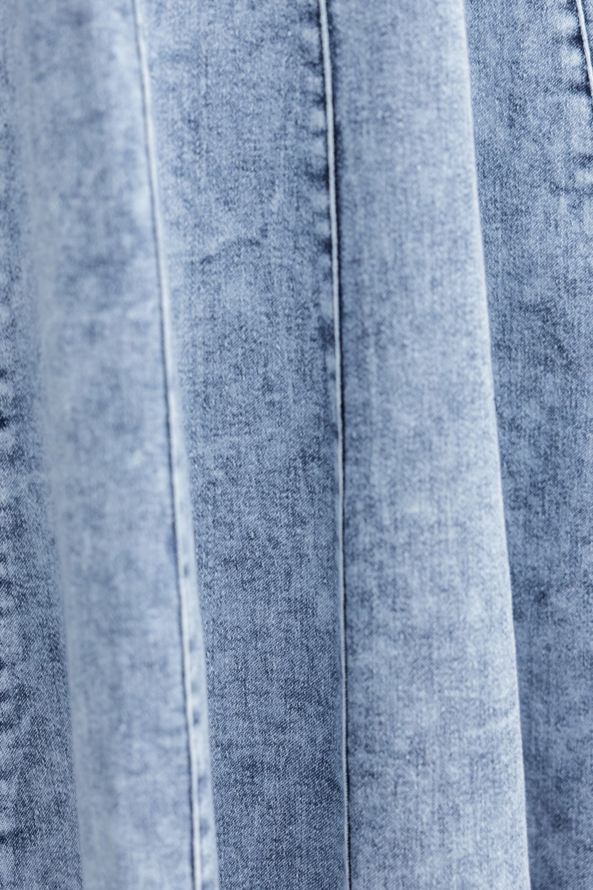 Close-up of light blue denim fabric featuring subtle panel detail for Annette Maxi Denim Dress.