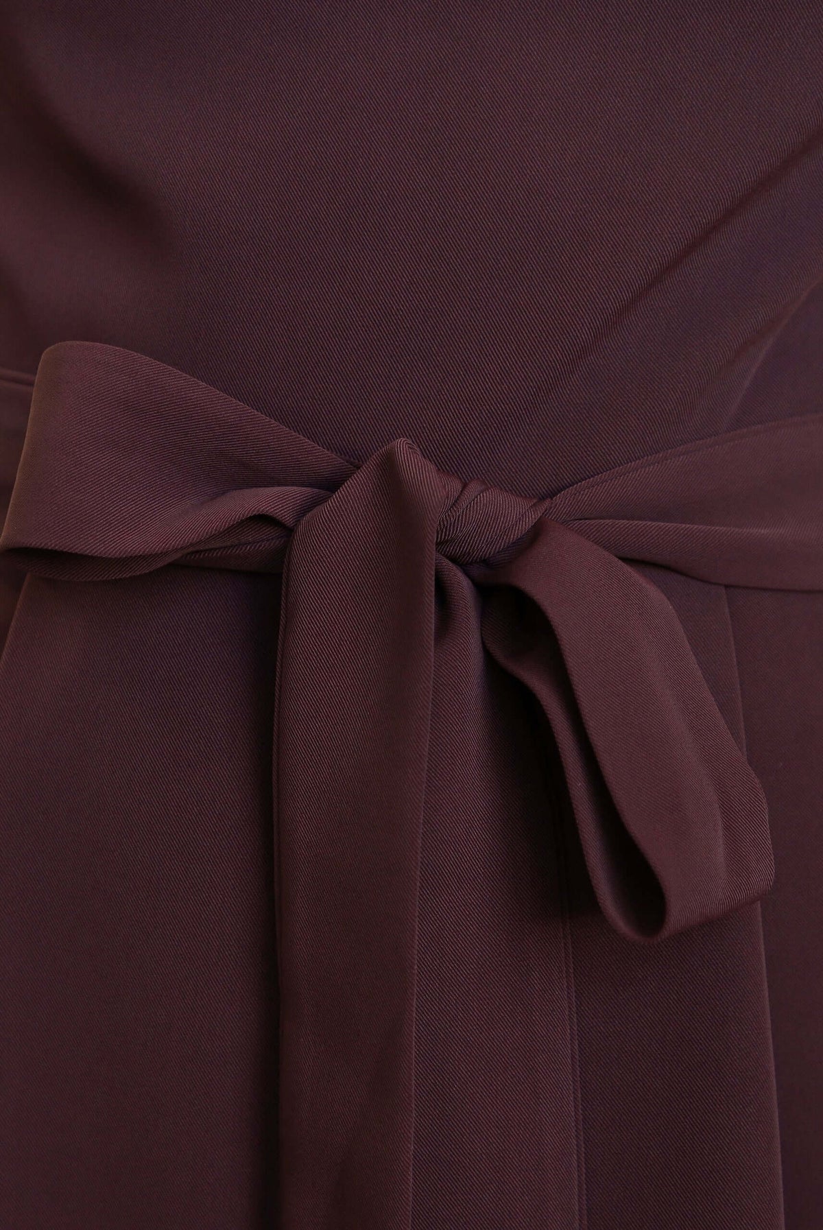 Detail of the removable tie on the Applause Jumpsuit, showcasing the soft fabric and stylish knot.