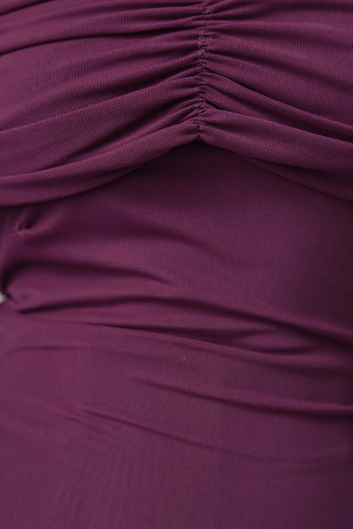 Close-up of Arcanna Top showing off-shoulder neckline and stretchy fabric in rich purple color.
