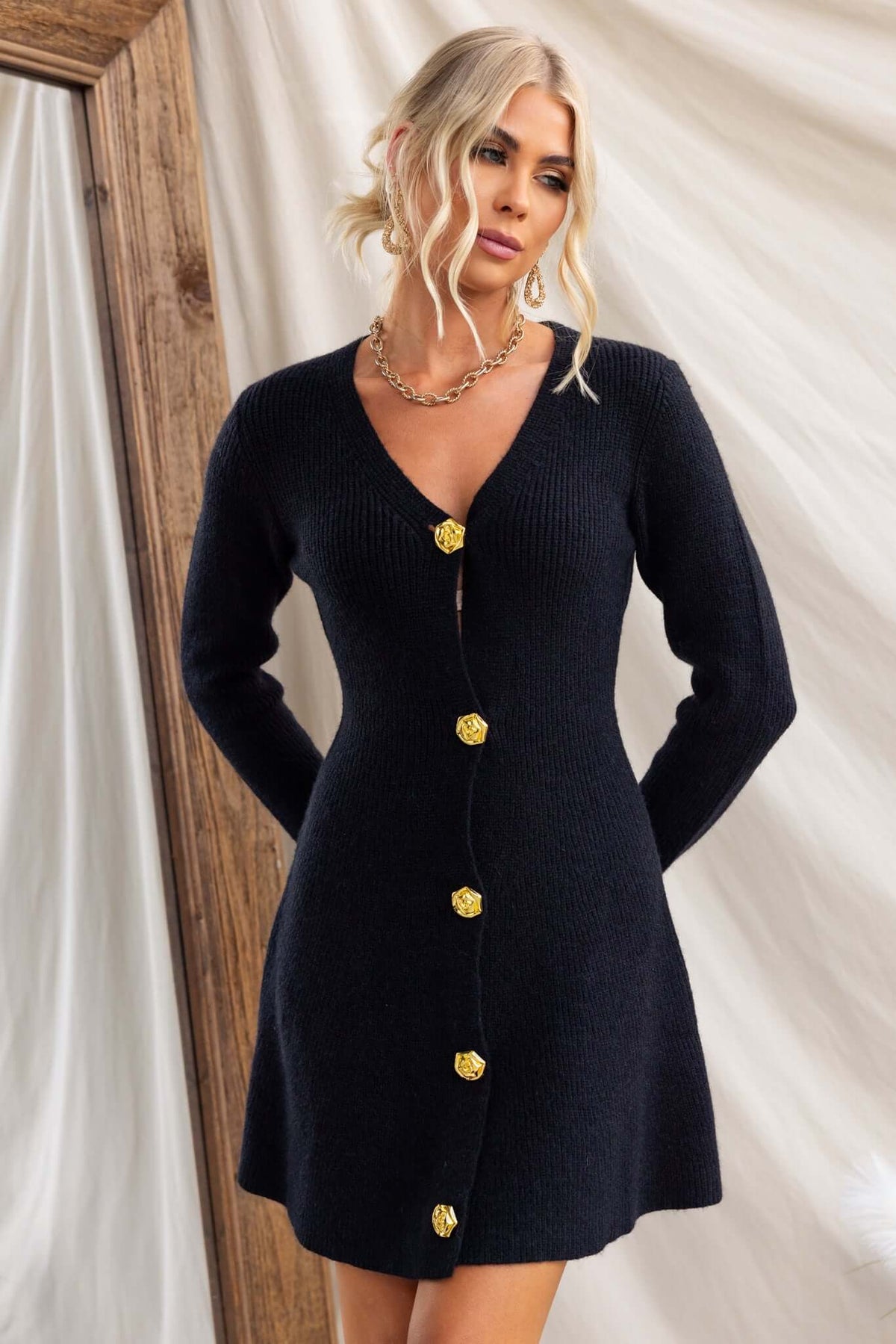Ballinger Dress featuring a V-neckline, button-up front, and ribbed knit material, worn by a model.