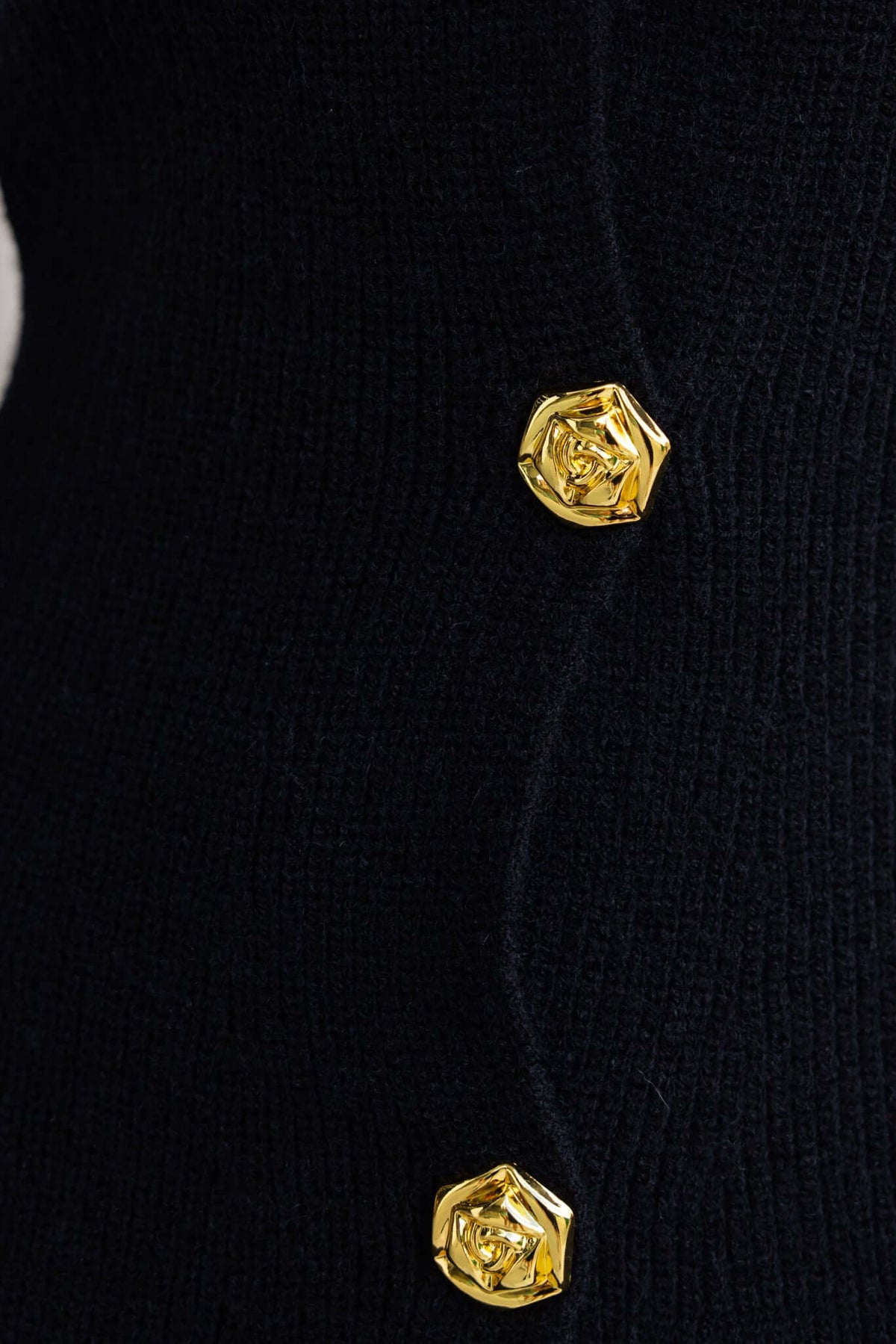 Close-up of gold button details on the Ballinger Dress featuring ribbed knit material.