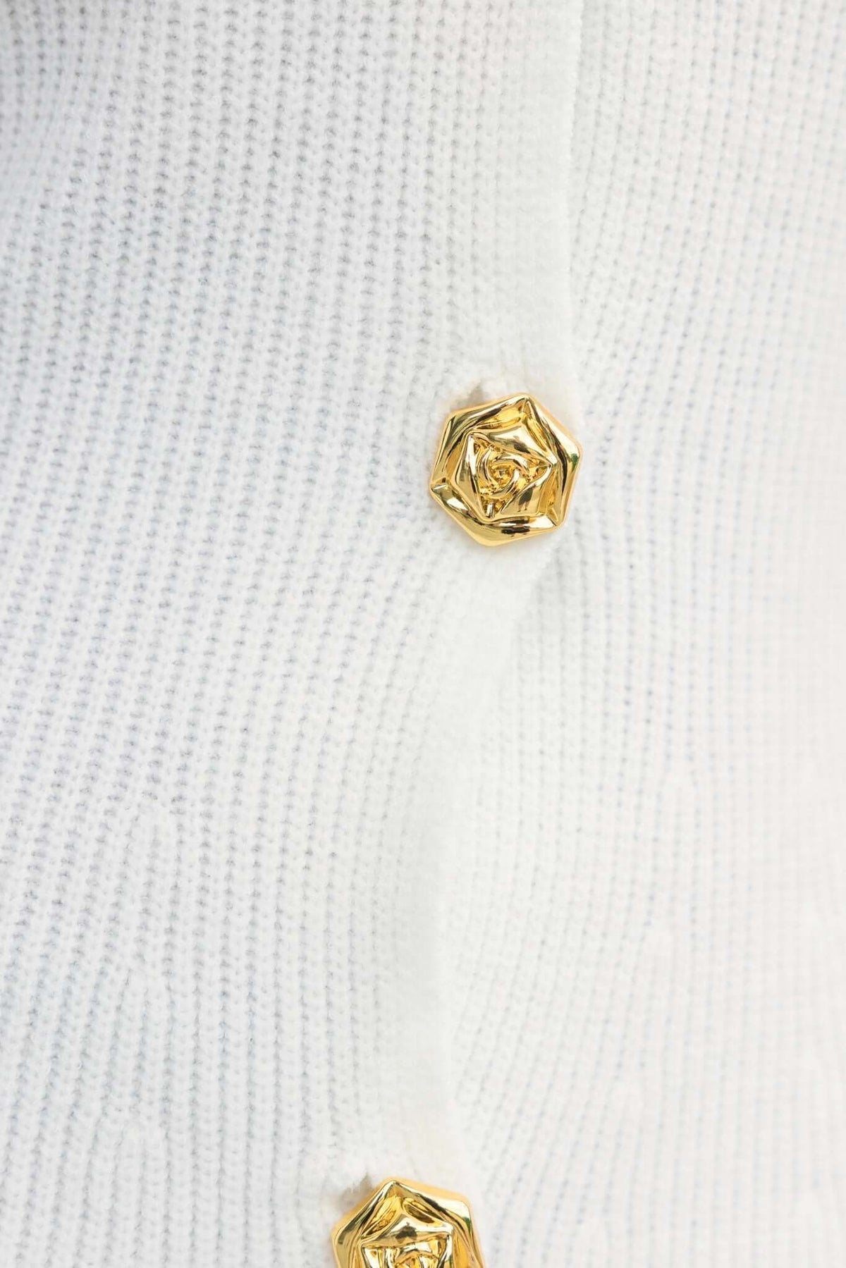 Close-up of Ballinger Dress showing V-neckline and gold buttons on ribbed knit material.