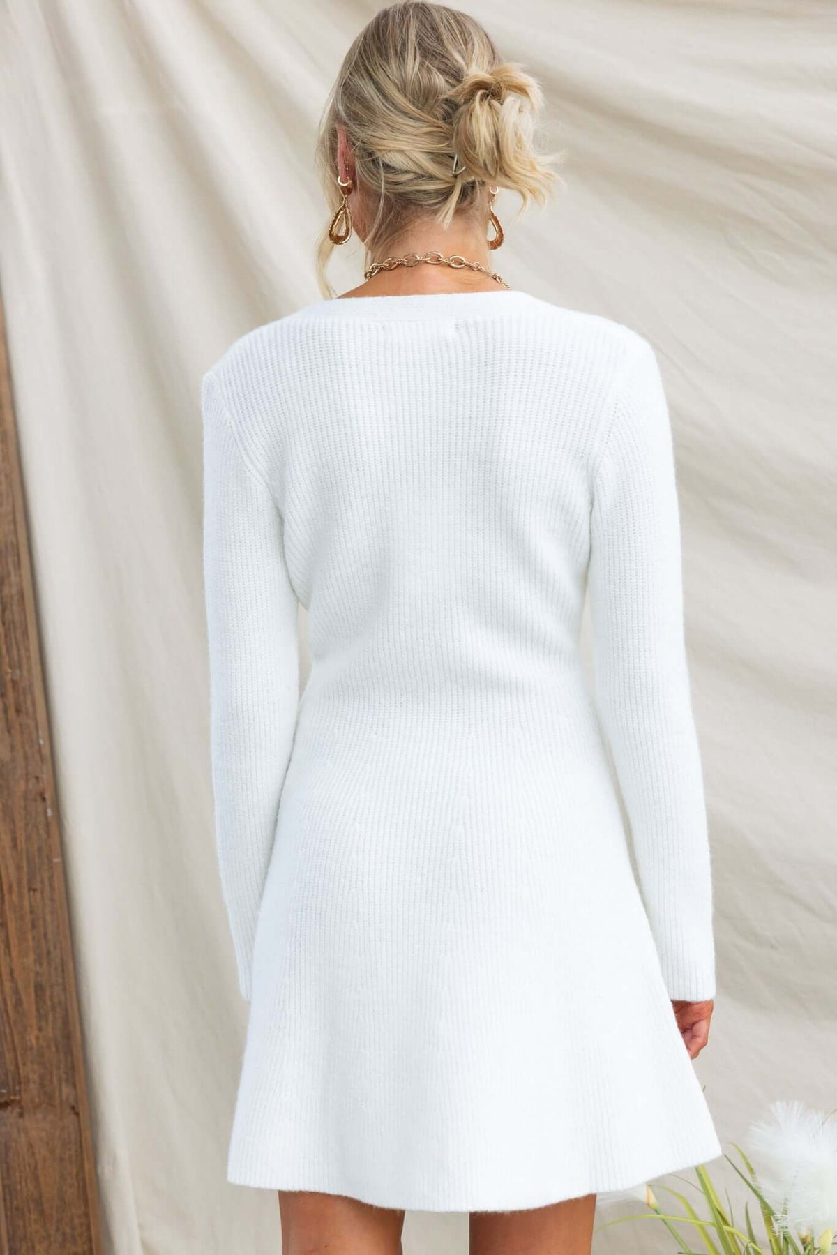 Back view of the Ballinger Dress in white, featuring ribbed knit material and long sleeves.