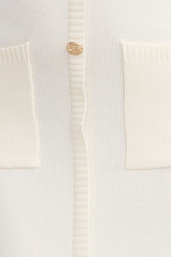Close-up of Bari Maxi Dress showing faux buttons and textured knit fabric with pockets in soft cream color.