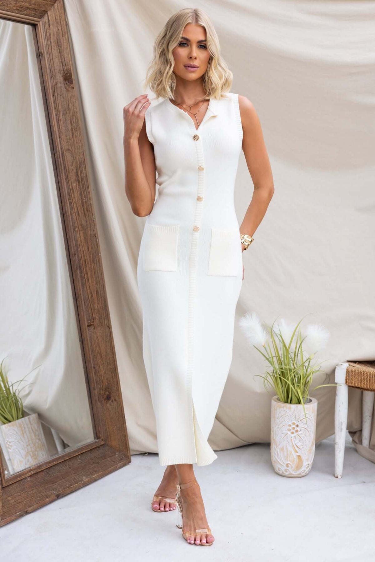 Bari Maxi Dress in white with high neckline, faux buttons, pockets, and front split, crafted in stretchy knit material.