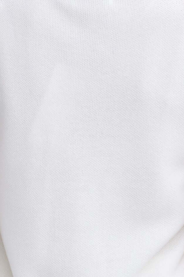 Close-up of Beacall Pants fabric, featuring a soft white knit material with a stretchy texture.