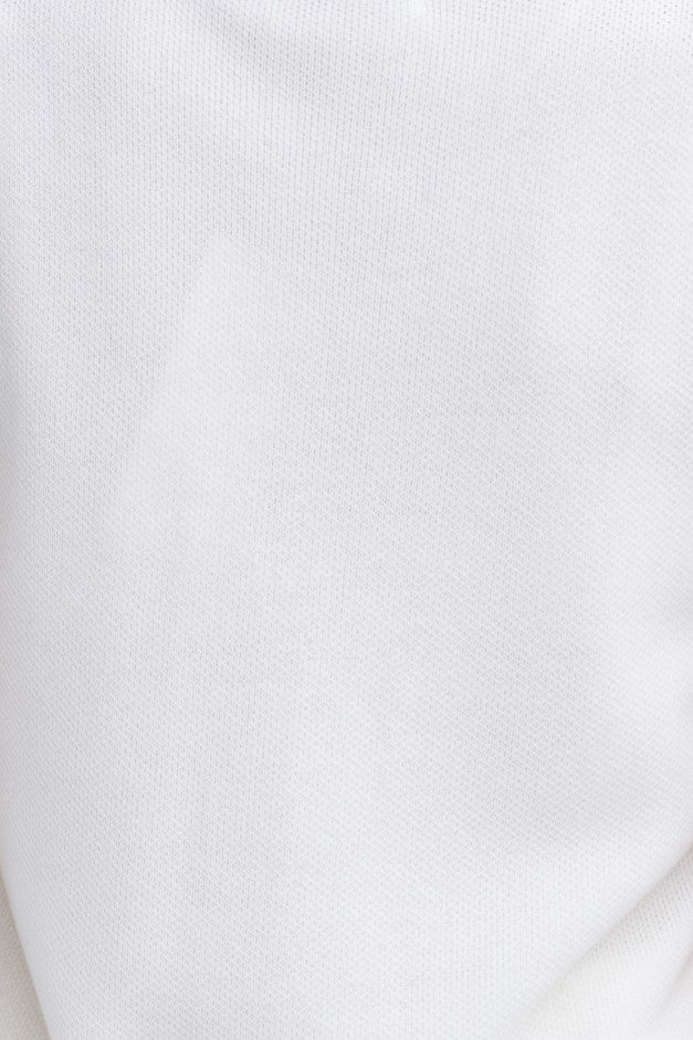 Close-up of Beacall Top knit material in white, showcasing its textured, stretchy fabric.