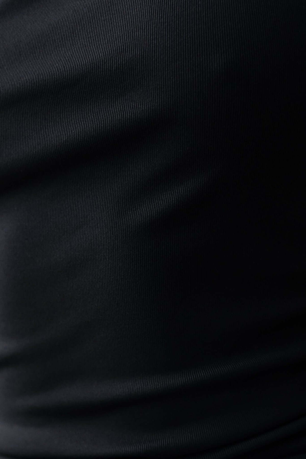 Close-up of black fabric texture showcasing the smooth and stretchy material of the Berkley Maxi Dress.
