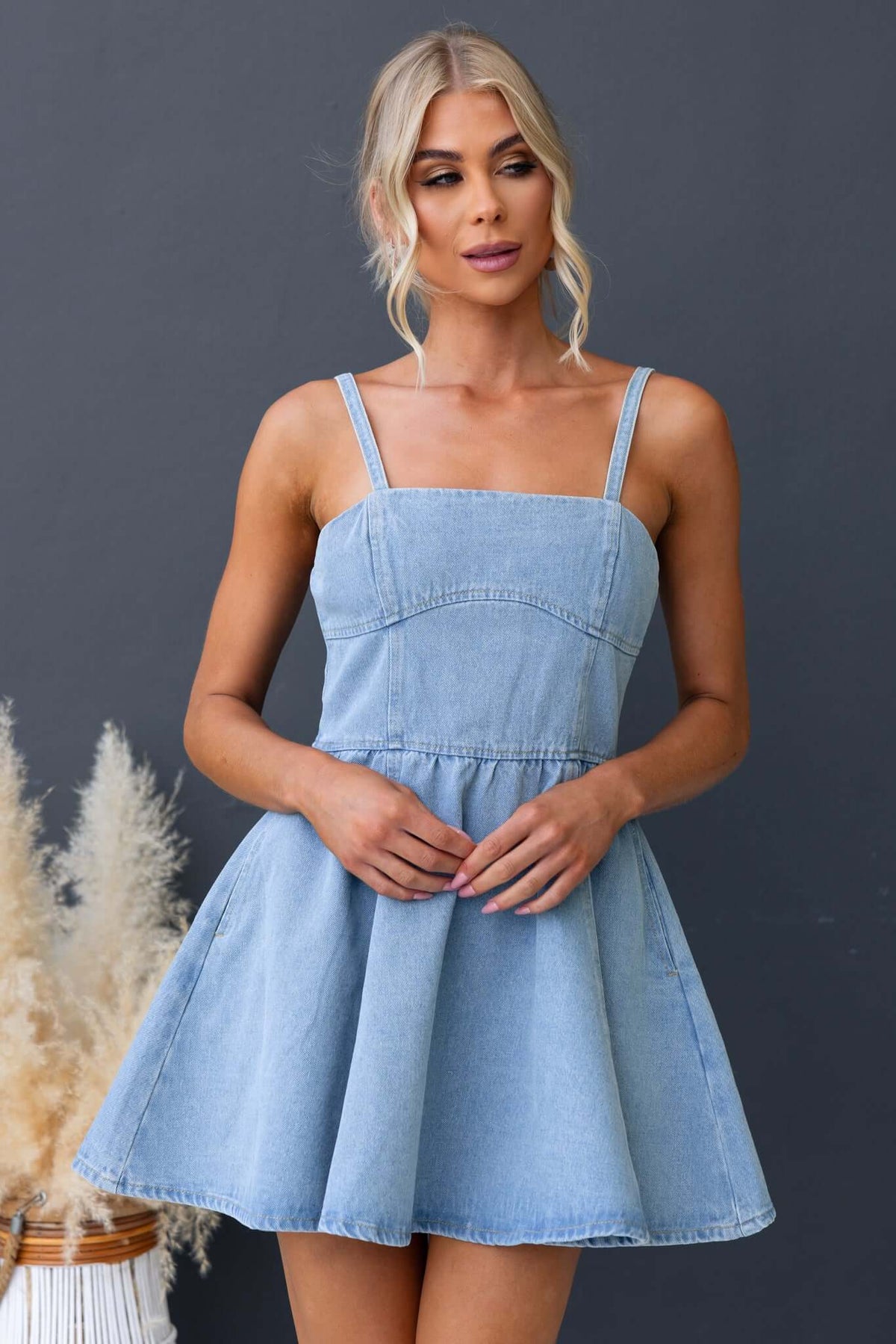 Light blue Bestie denim dress with adjustable straps, zip back, and pockets, model wearing size 6/XS.