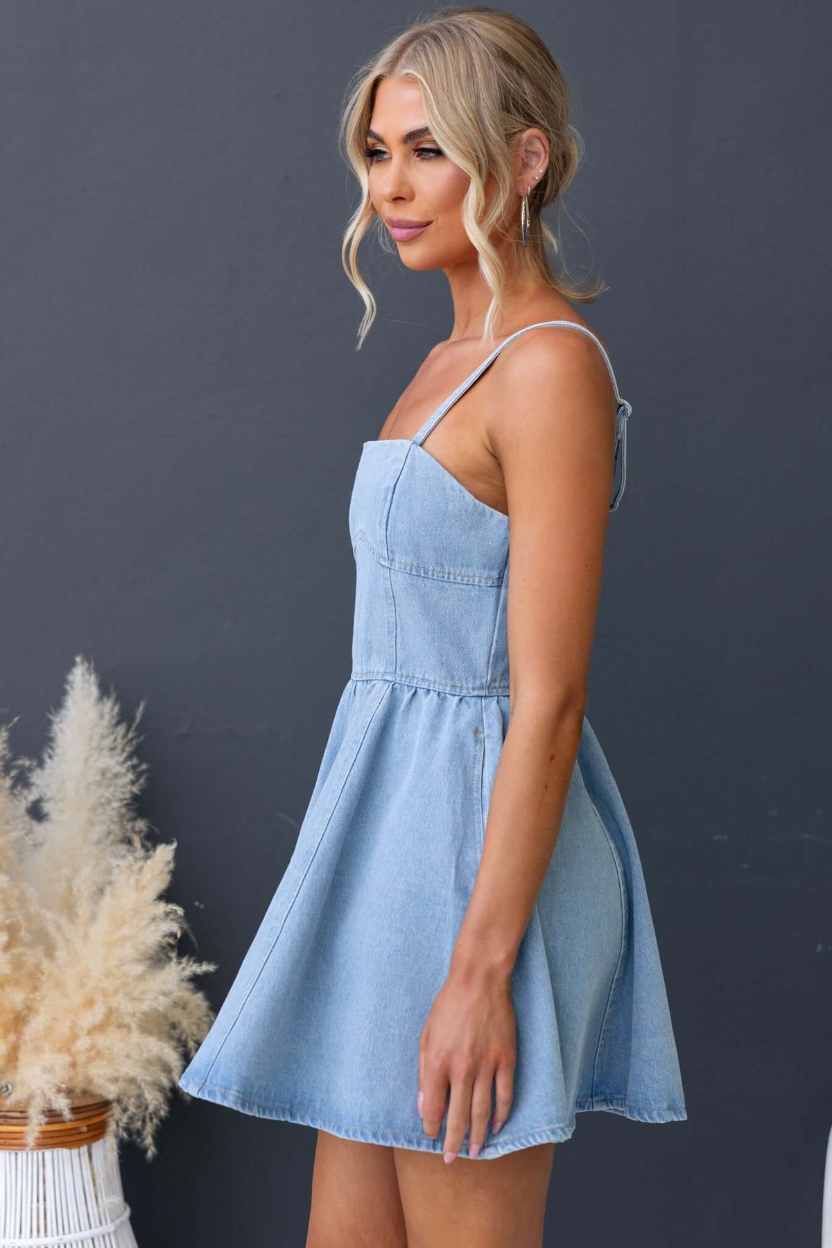 Bestie denim dress featuring adjustable straps, pockets, and a zip at the back, perfect for a stylish summer look.
