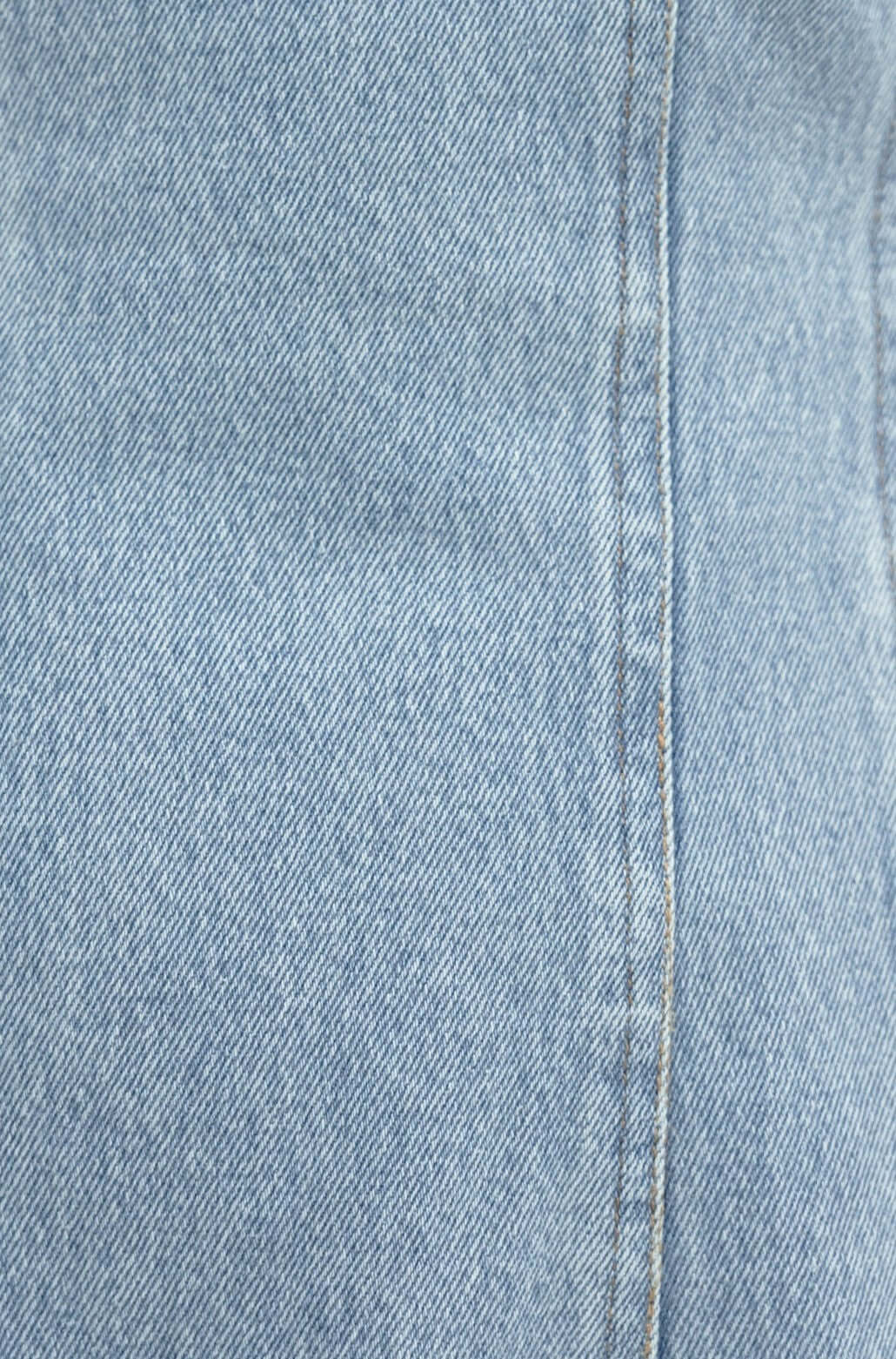 Close-up of light blue denim fabric showcasing texture and stitching of the Bestie Denim Dress.