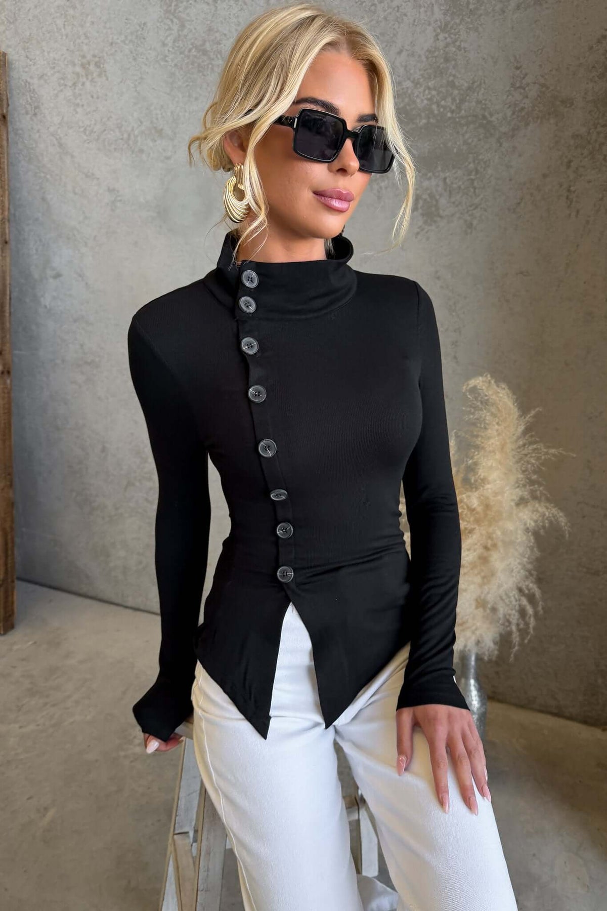 Josia Top in black with round neckline and faux button-up front, worn by a model with sunglasses.