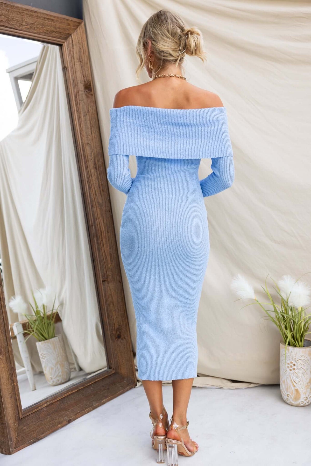 Back view of a light blue off-shoulder midi dress made from ribbed knit material, perfect for a casual chic look.