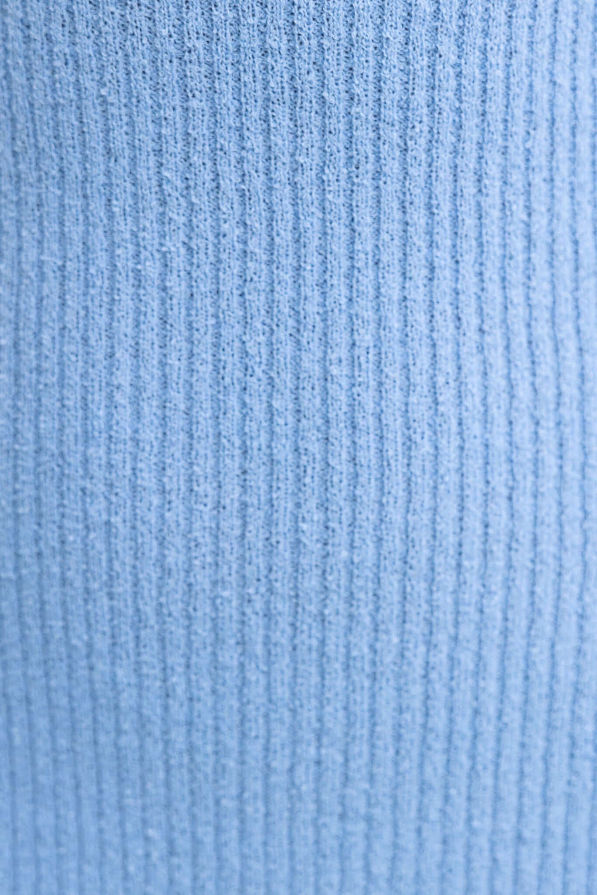 Close-up of light blue ribbed knit fabric, showcasing the texture and stretch of the material used in the Breeze Midi Dress.