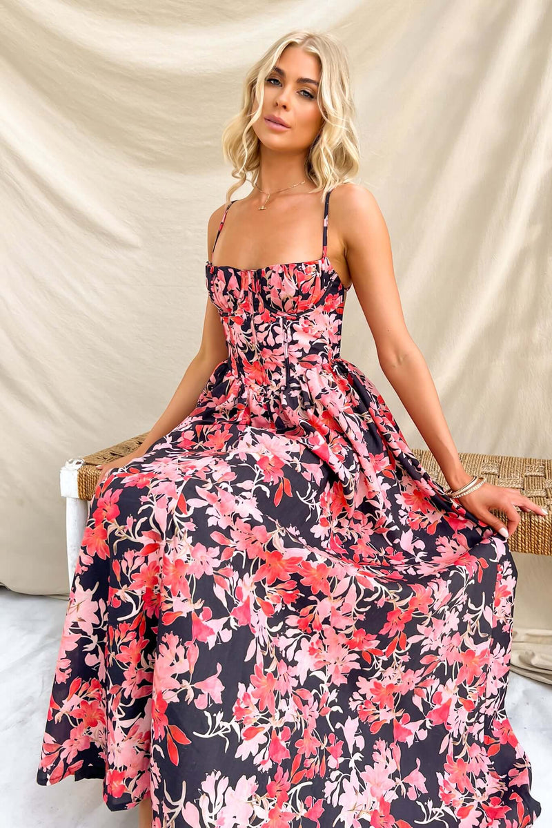 Model wearing Burkes Midi Dress with floral pattern, adjustable straps, and flattering skirt. Perfect for summer outings.