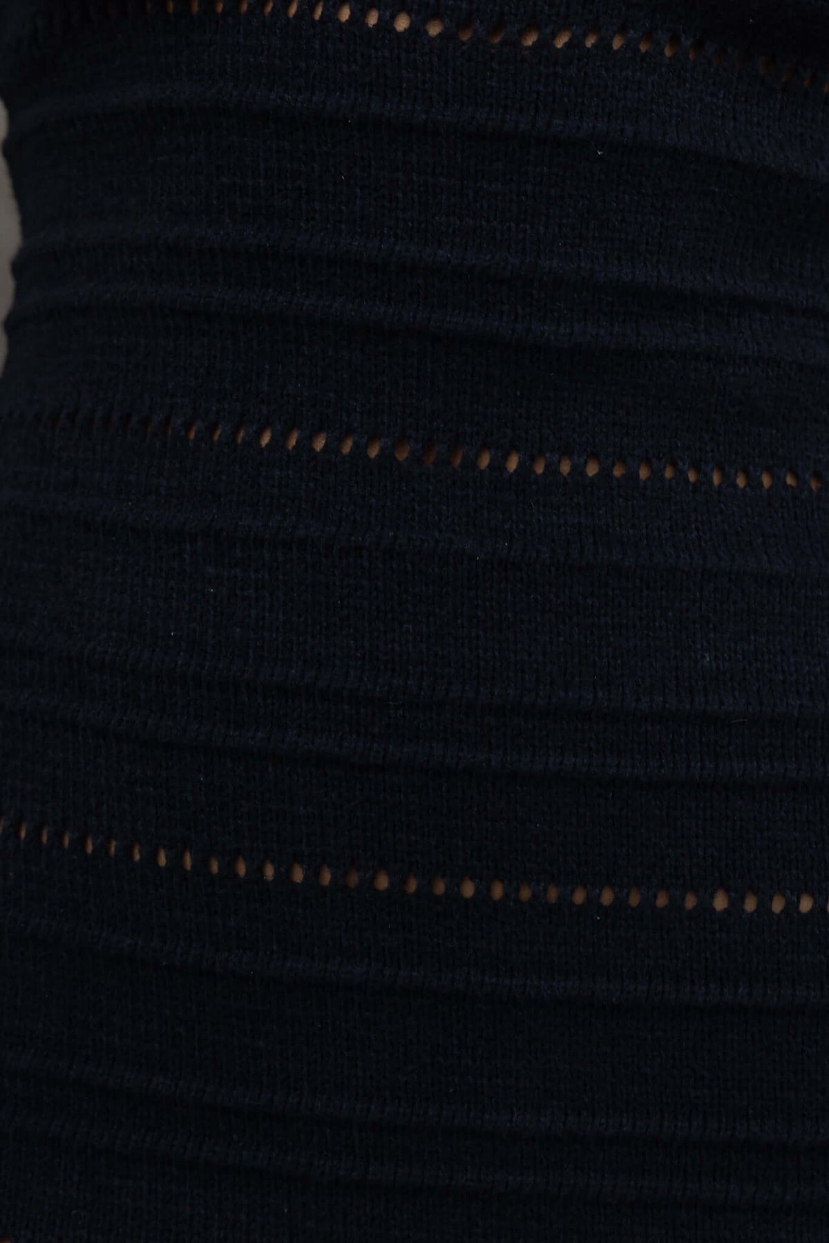 Close-up of open-weave knit material of Calvery Maxi Dress featuring twist neckline and stretch fabric.