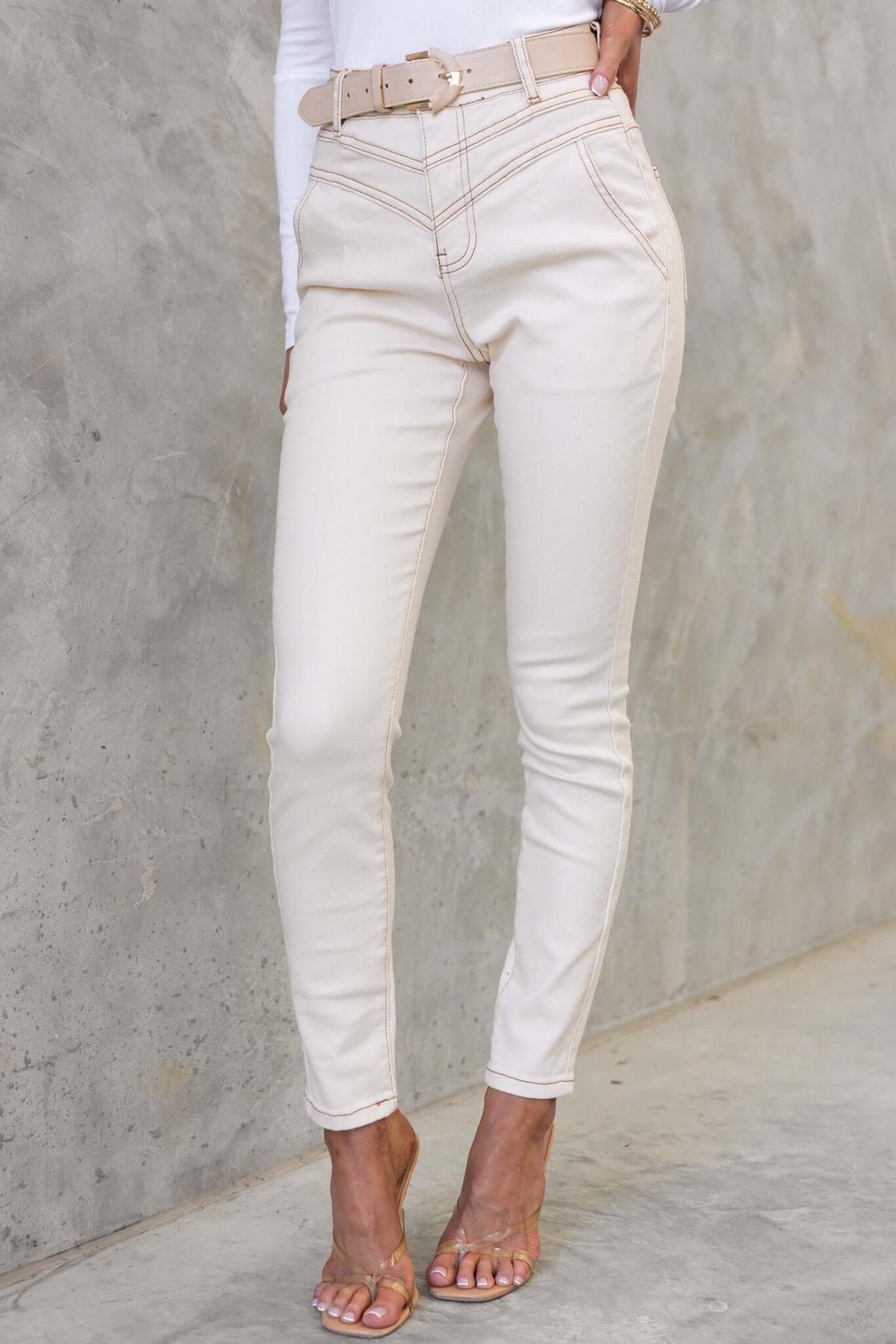 Caprice Jeans in light beige with mid-high waist, skinny fit, and belt detail, perfect for stylish casual wear.
