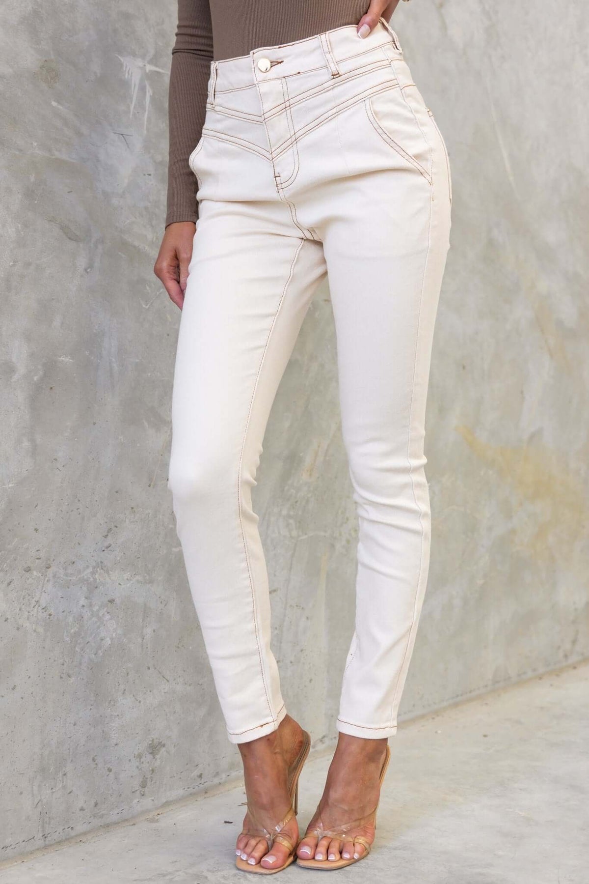 Caprice Jeans in cream color, featuring a mid-high waist, skinny fit, and stylish pockets.