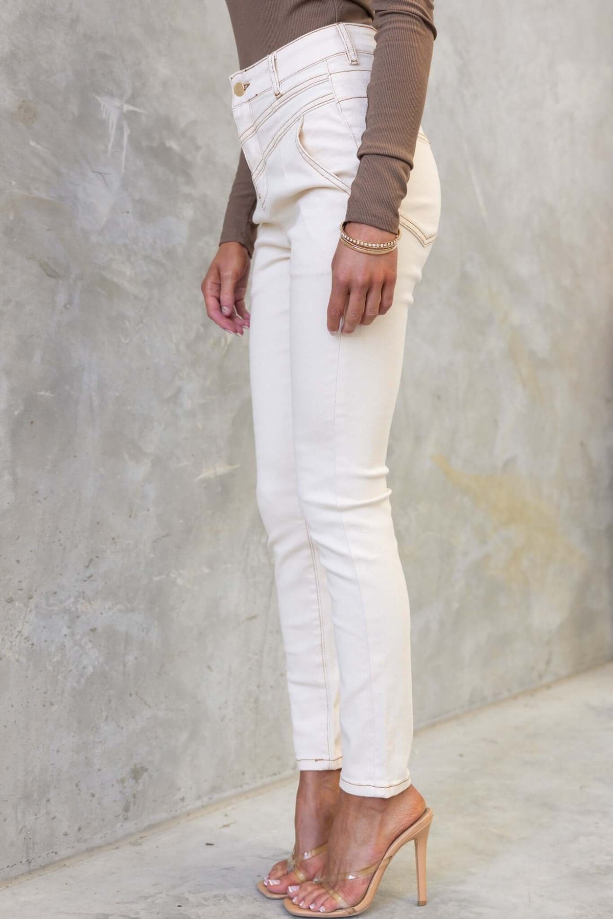 Stylish Caprice jeans in ivory with a mid-high waist, paired with a fitted top and heels for a chic look.