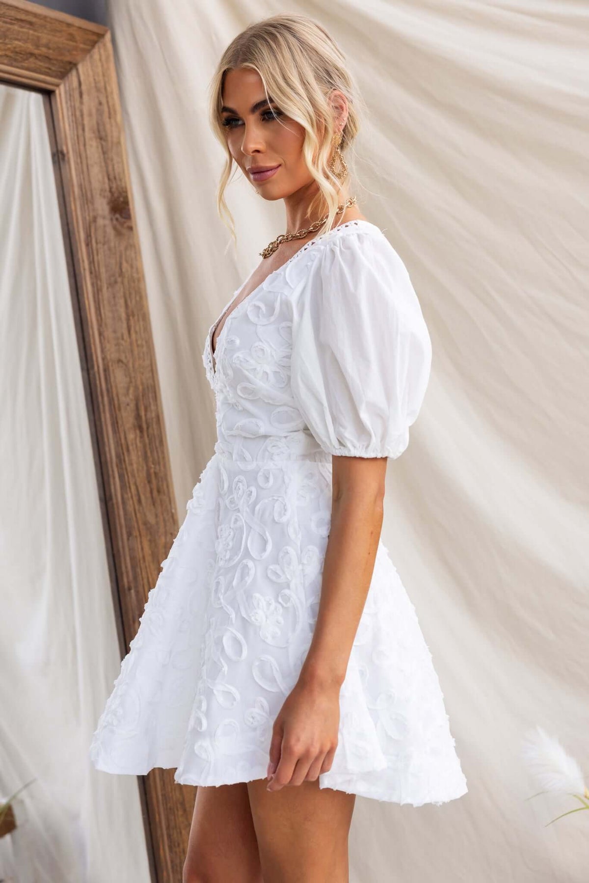 Casen Dress featuring a V-neckline, elastic cuffs, and a flared skirt in white, perfect for a summer outing.