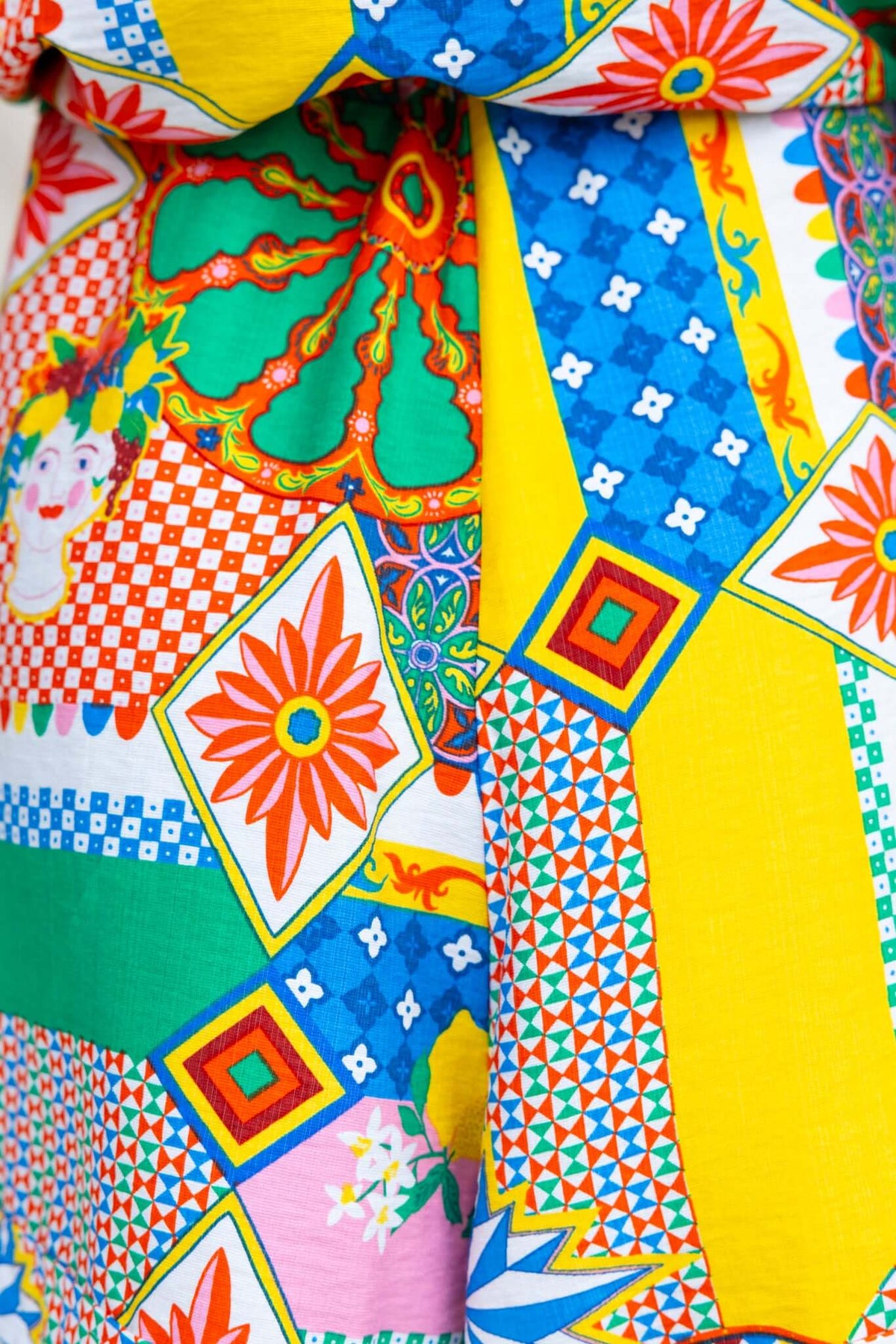 Colorful patterned fabric of a playsuit featuring vibrant floral and geometric designs.
