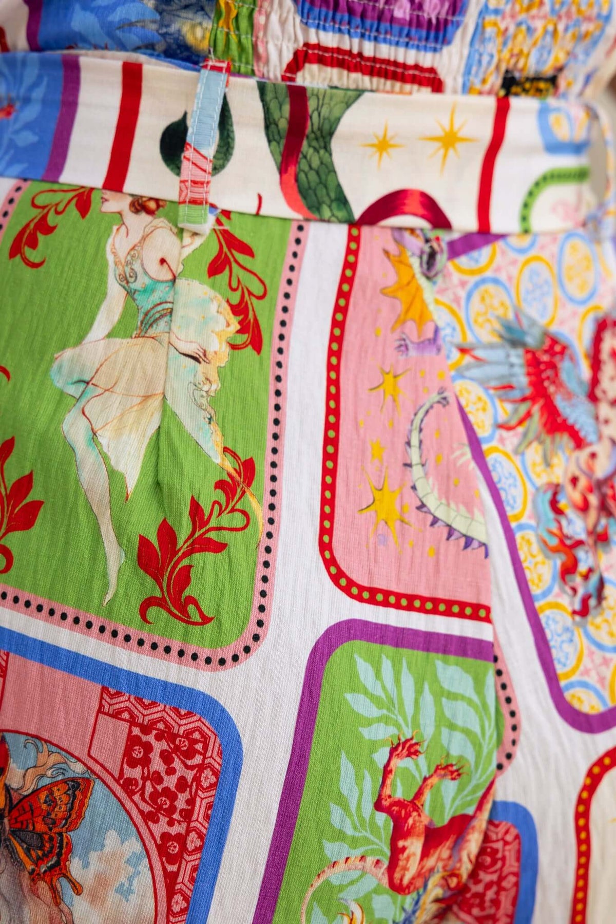 Colorful patterned fabric detail of the Fidenz Jumpsuit featuring artistic prints and vibrant colors.