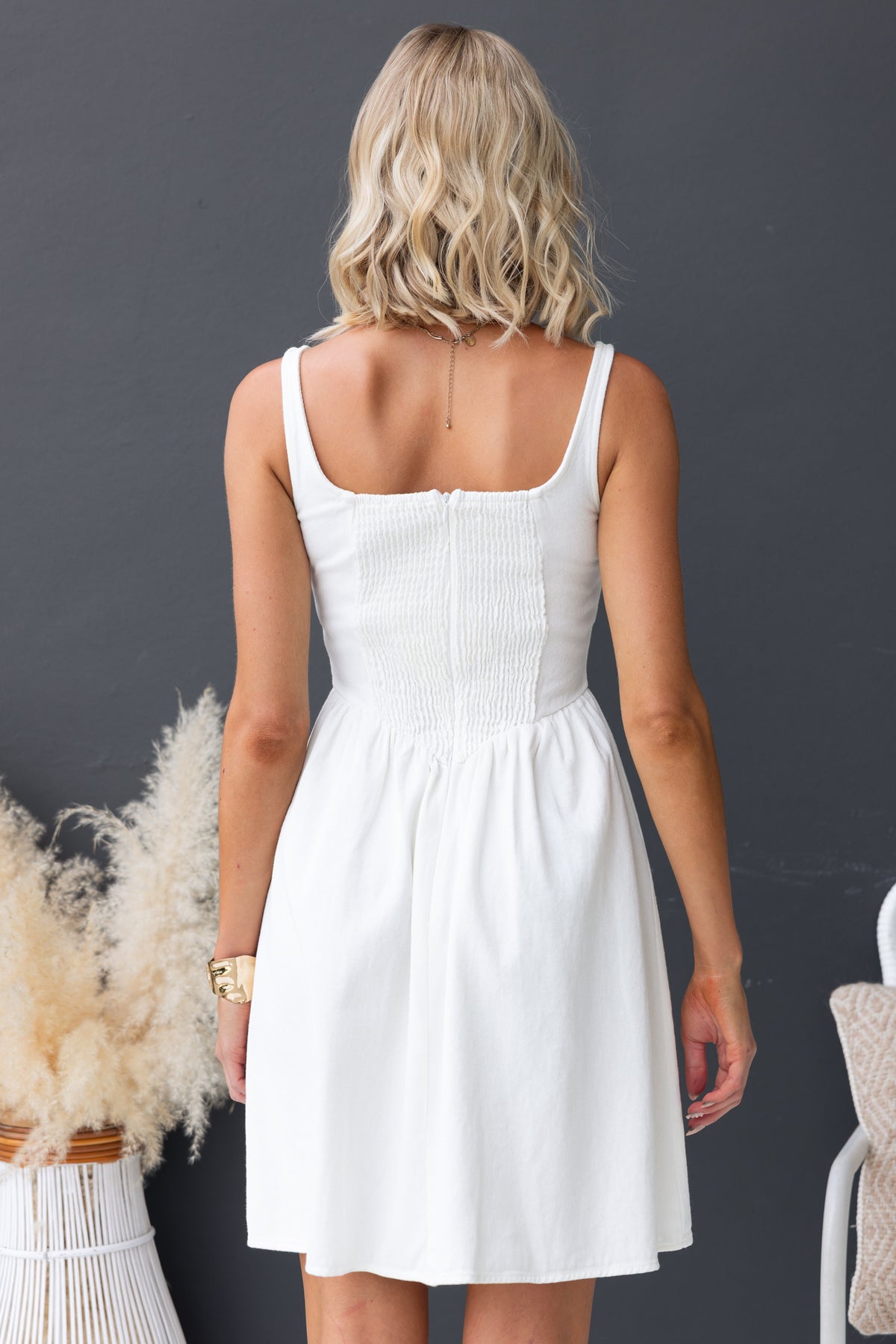 Back view of a woman wearing a Cullman denim dress featuring an elastic back and invisible zip, made from 100% cotton.