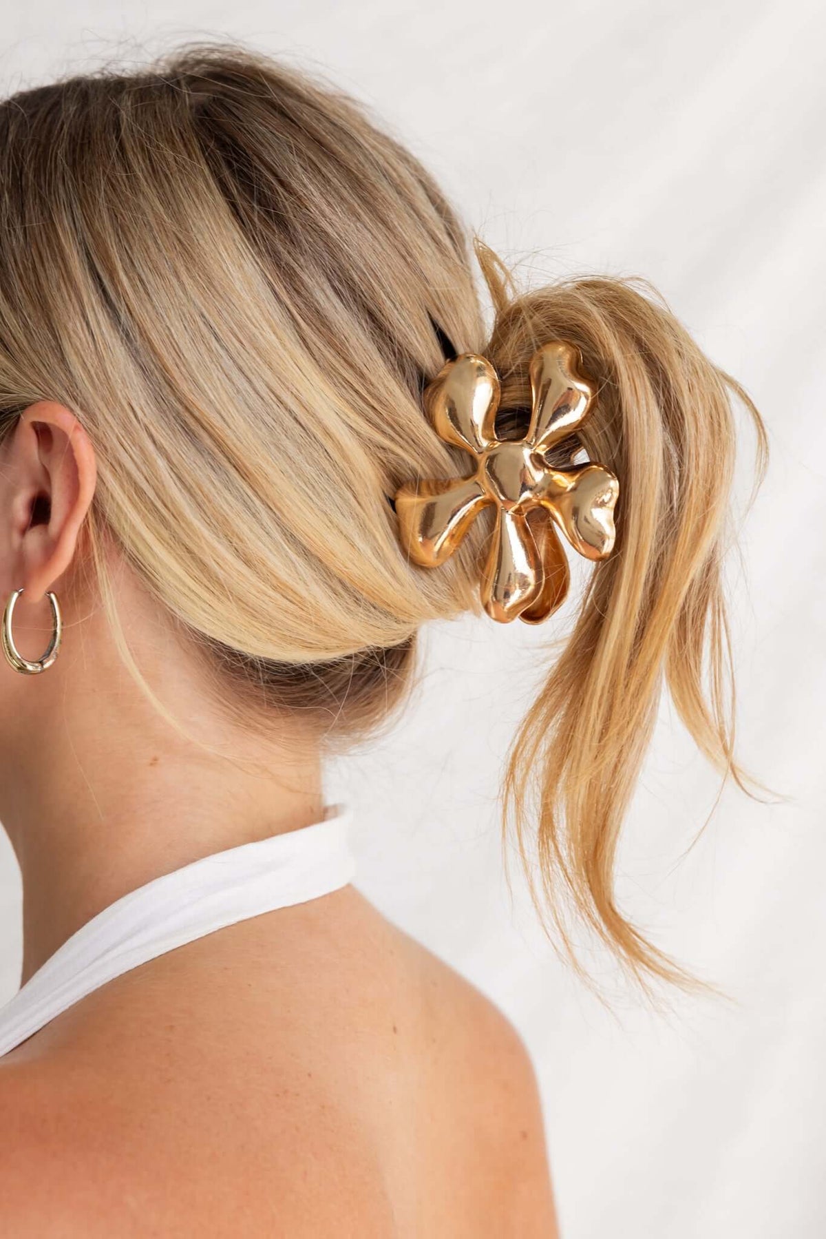Daisy claw clip with metallic finish, styled in blonde hair, 7.5cm length, perfect for elegant hairstyles.