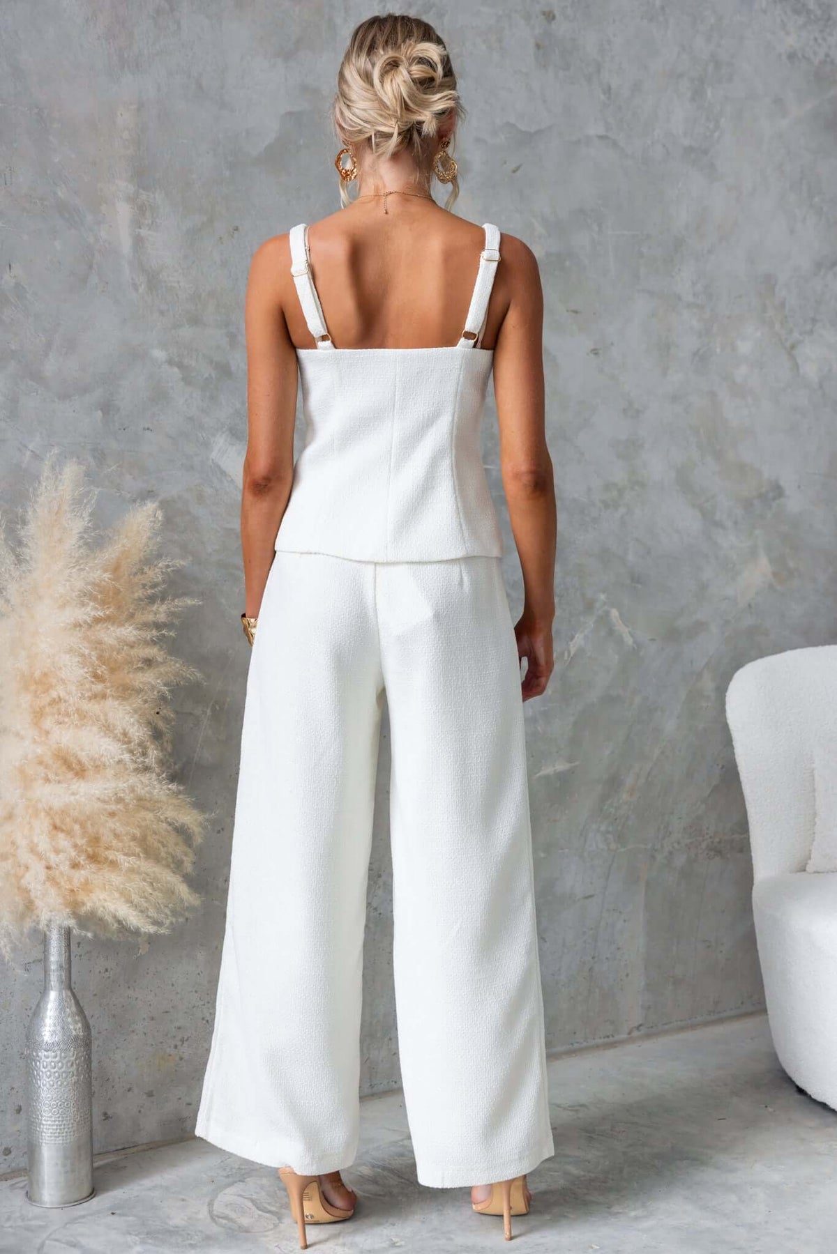 Back view of a woman in a cream chenille square neck top and mid-high waist pants, stylish and contemporary outfit.