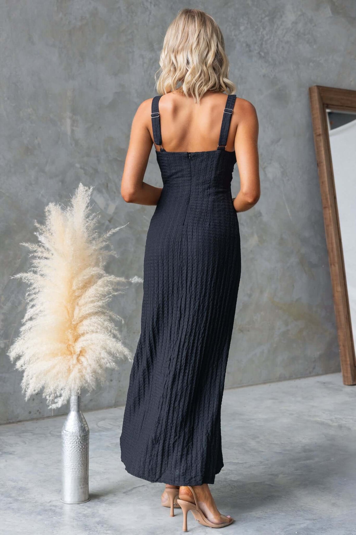 Back view of a black Dedication Maxi Dress with adjustable straps and textured fabric, perfect for stylish summer outings.