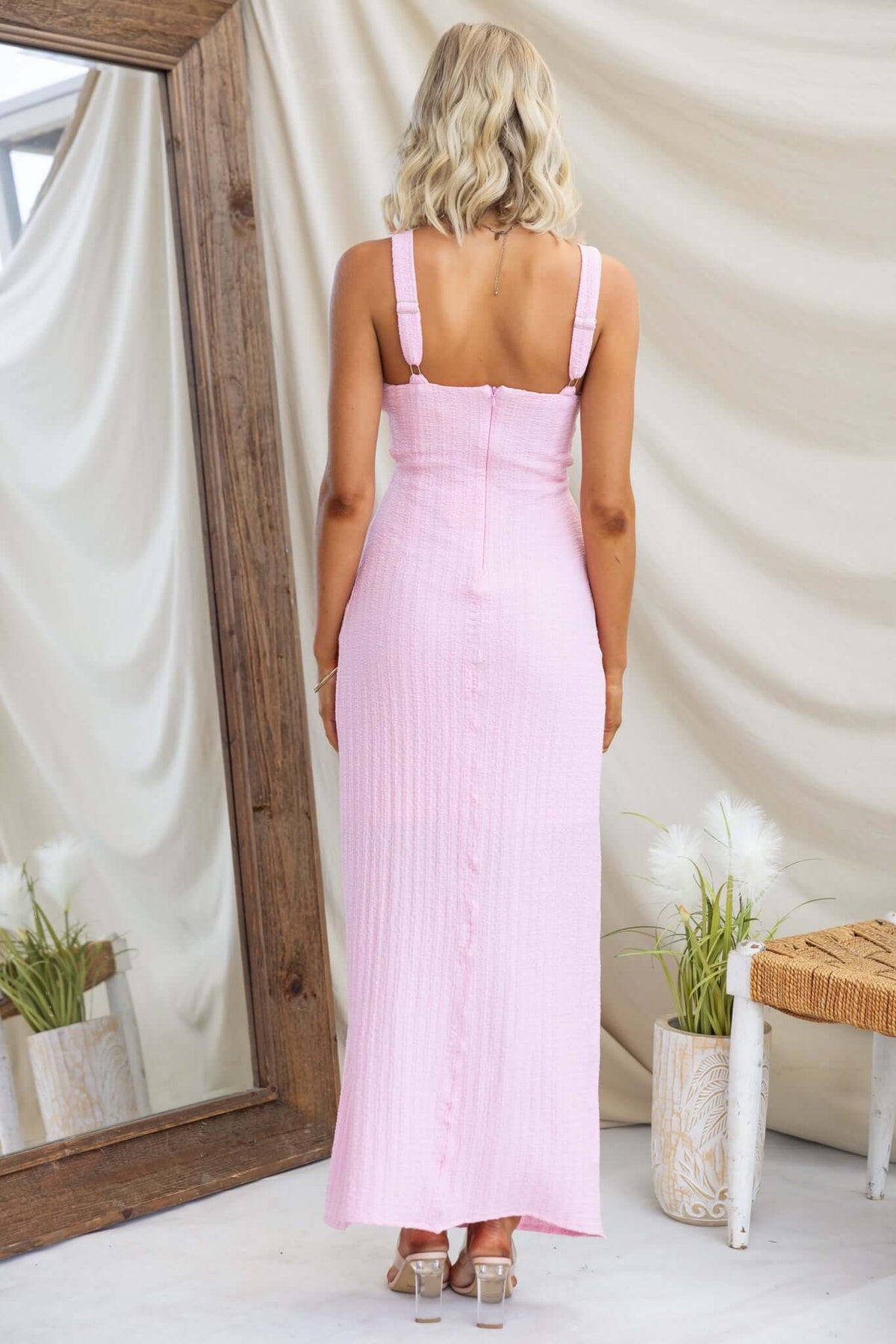 Back view of Dedication Maxi Dress featuring adjustable straps, textured pink material, and a cut-out at the waist.