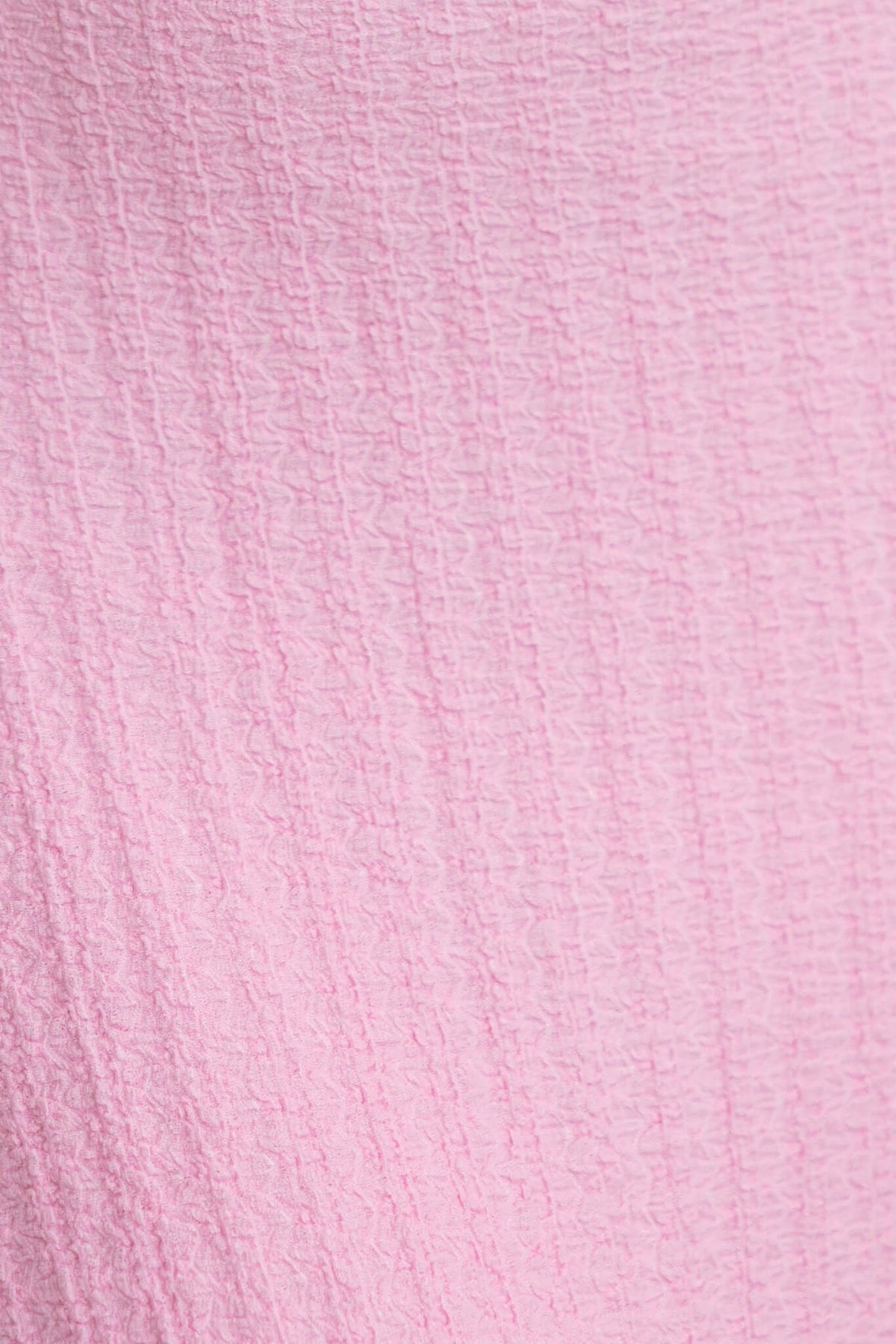 Textured pink fabric close-up of the Dedication Maxi Dress, showcasing its soft and stretchy material.